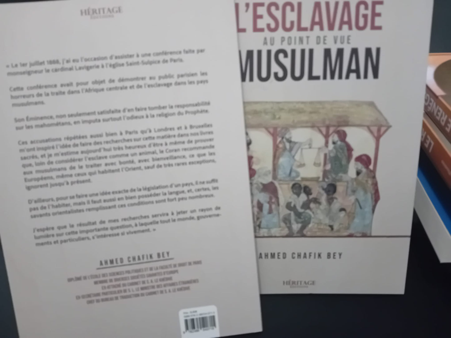 Couverture du livre "L’Esclavage au point de vue musulman" d’Ahmed Chafik Bey, publié chez Héritage Éditions, illustrée par une scène historique orientale représentant un marché d’esclaves sous un auvent, sur fond beige.