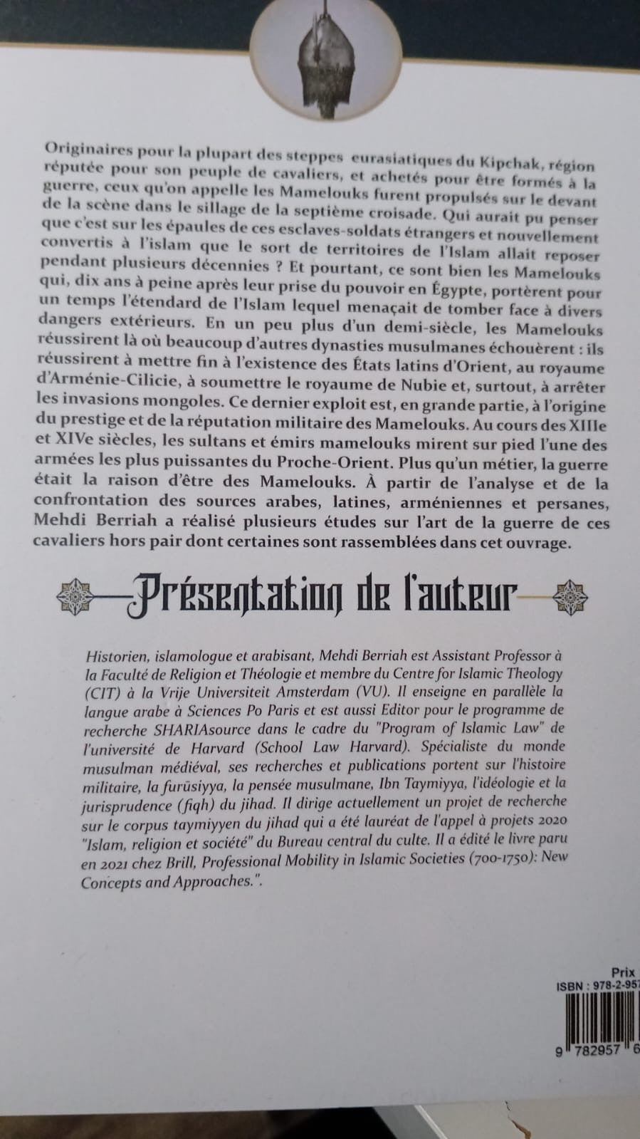 Photographie du livre Les Mamelouks – Les cavaliers de l’Islam de Mehdi Berriah, mis en valeur sur fond beige. La couverture richement illustrée s’inspire de miniatures orientales, représentant des guerriers mamelouks en armes dans des tons éclatants de bleu, or, rouge et blanc. Le titre en lettres gothiques domine l’ouvrage, qui traite de l’art de la guerre chez les Mamelouks aux XIIIe et XIVe siècles