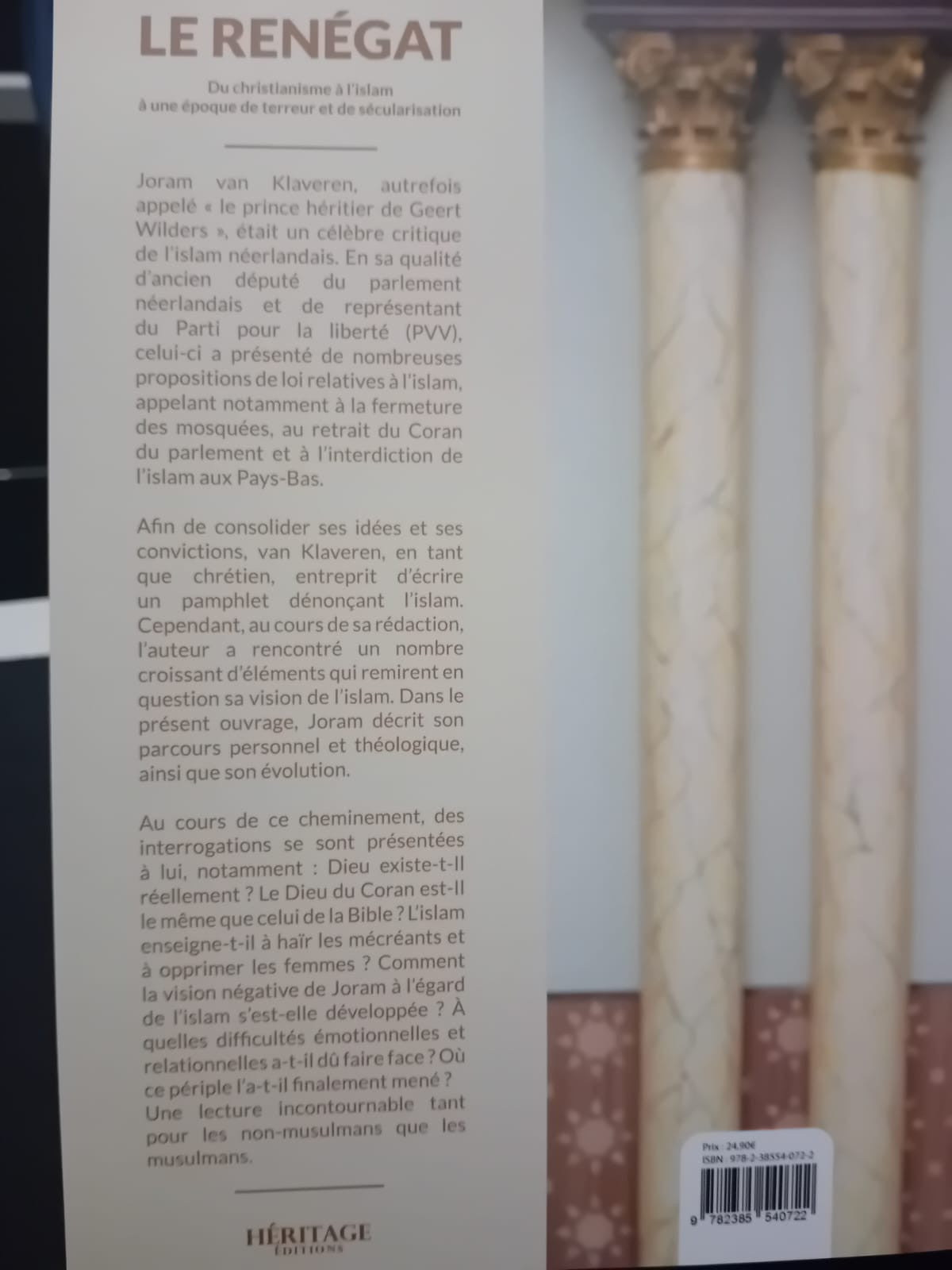 Couverture du livre Le Renégat de Joram van Klaveren, montrant l’auteur debout en costume dans une mosquée, sous un lustre, les mains dans les poches et le regard sérieux.