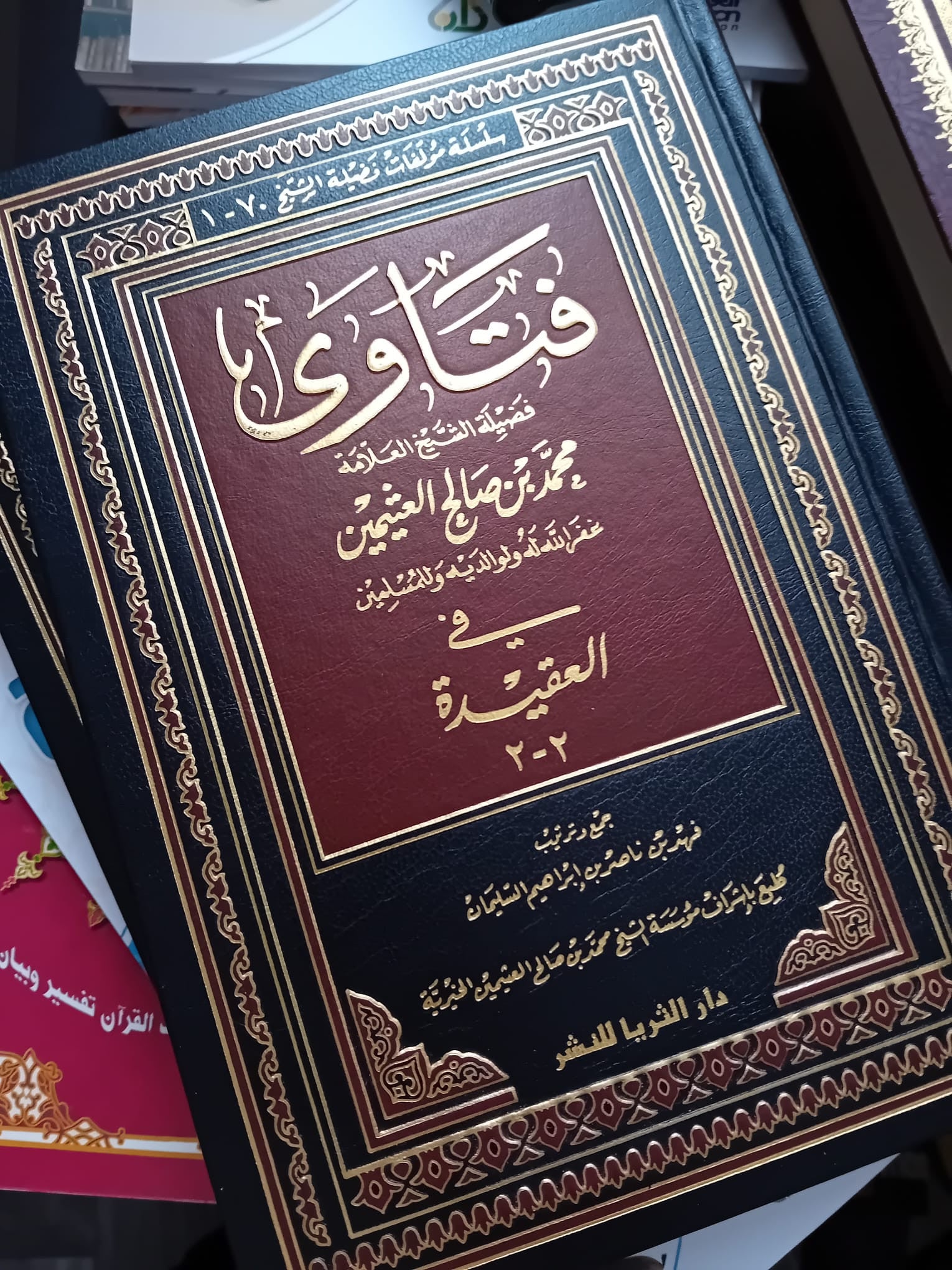 Présentation du livre 'Fatawa' du cheikh Ibn Uthaymin dans un décor noble et lumineux, pour mettre en valeur sa richesse et son importance.