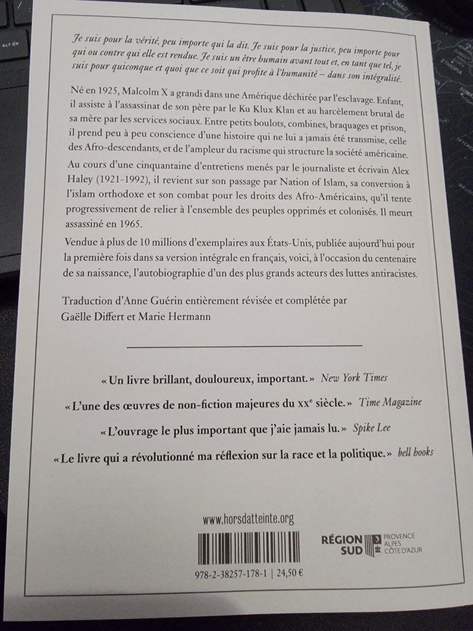 Couverture du livre L’autobiographie de Malcolm X, recueillie par Alex Haley, avec une photo en noir et blanc de Malcolm X portant des lunettes et un costume, posée sur une étagère en bois.