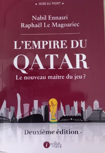 Photographie du livre L’Empire du Qatar – Le nouveau maître du jeu ? (deuxième édition) de Nabil Ennasri et Raphaël Le Magoariec, posé debout sur une table en bois clair, avec en arrière-plan un rideau blanc doux et lumineux. La couverture bordeaux du livre est mise en valeur dans une ambiance sobre et élégante.