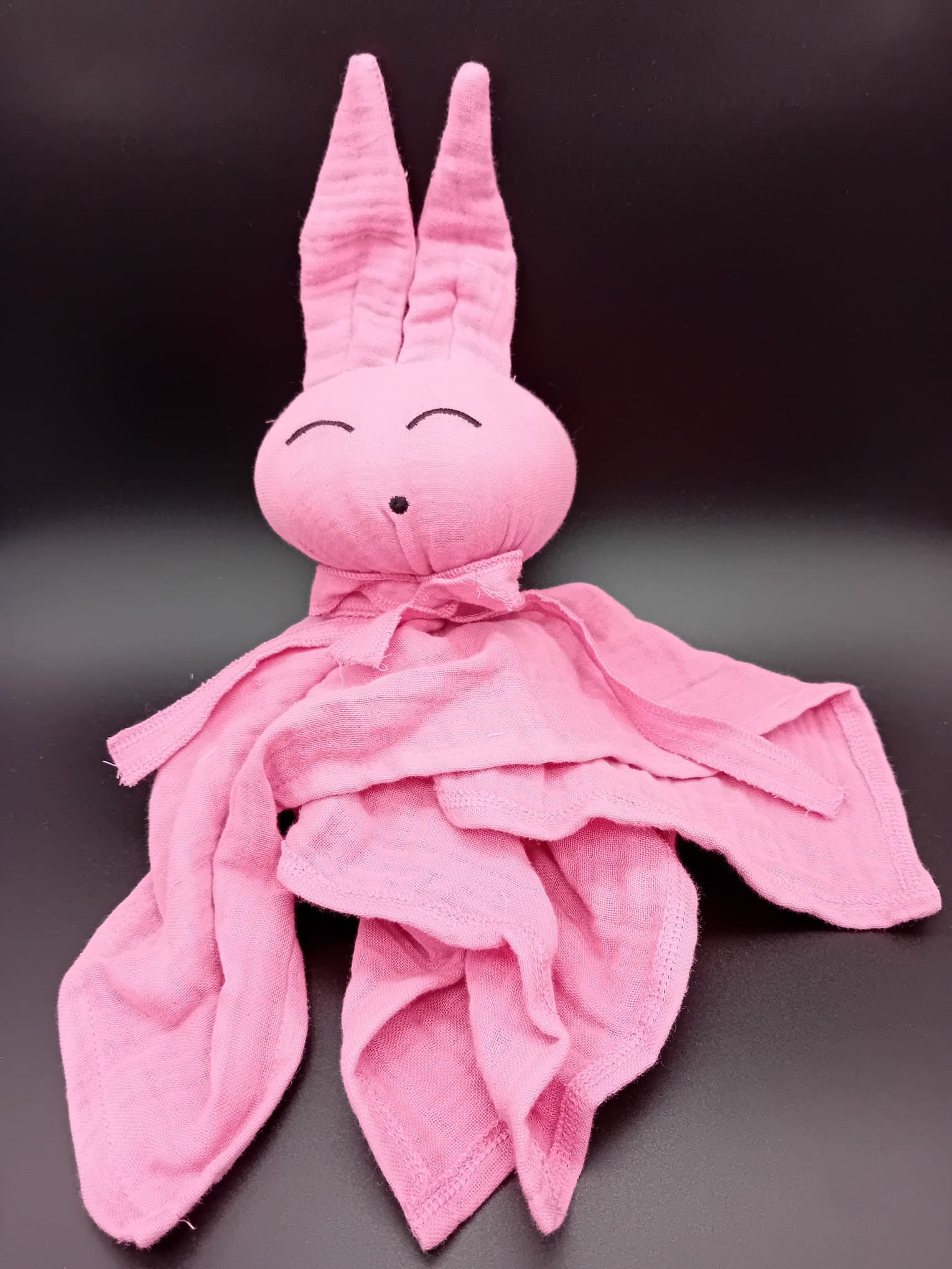 Doudou lapin en coton tout doux, coloris rose tendre, avec de longues oreilles et un visage apaisant cousu à la main. Idéal pour apaiser bébé et l'accompagner dès la naissance