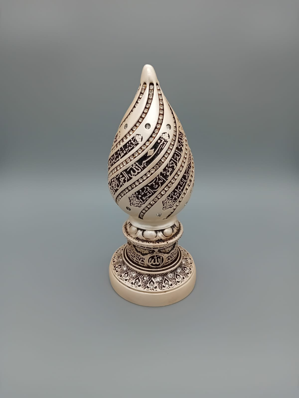 bibelot décoratif en forme d'œuf, orné de l'Ayatou l-Koursi, apporte une touche spirituelle et élégante à votre intérieur. Fabriqué en Turquie avec soin, il mesure 18 cm de hauteur et présente une couleur crème raffinée, idéale pour s’intégrer harmonieusement dans tout type de décoration