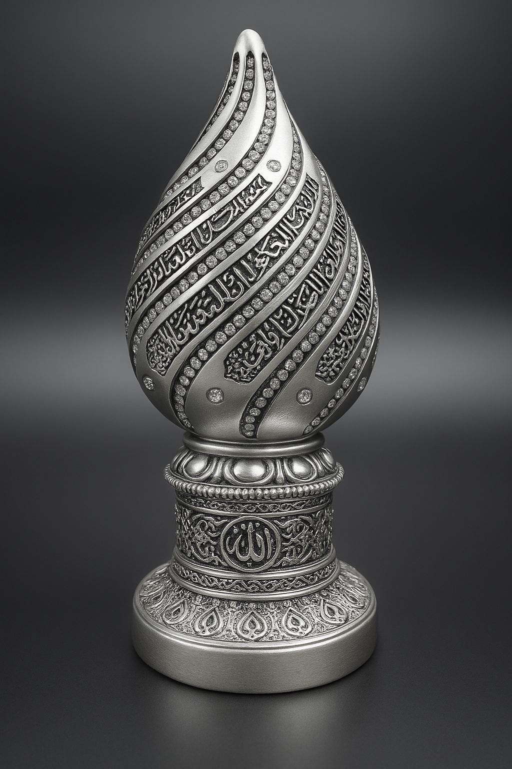 Élégant bibelot décoratif de couleur argentée, en forme de goutte élancée, orné de calligraphies arabes et de pierres scintillantes. Sa base finement ciselée arbore le nom d’Allah et des motifs géométriques inspirés de l’art islamique. Un objet raffiné, idéal pour sublimer une pièce avec spiritualité et distinction.