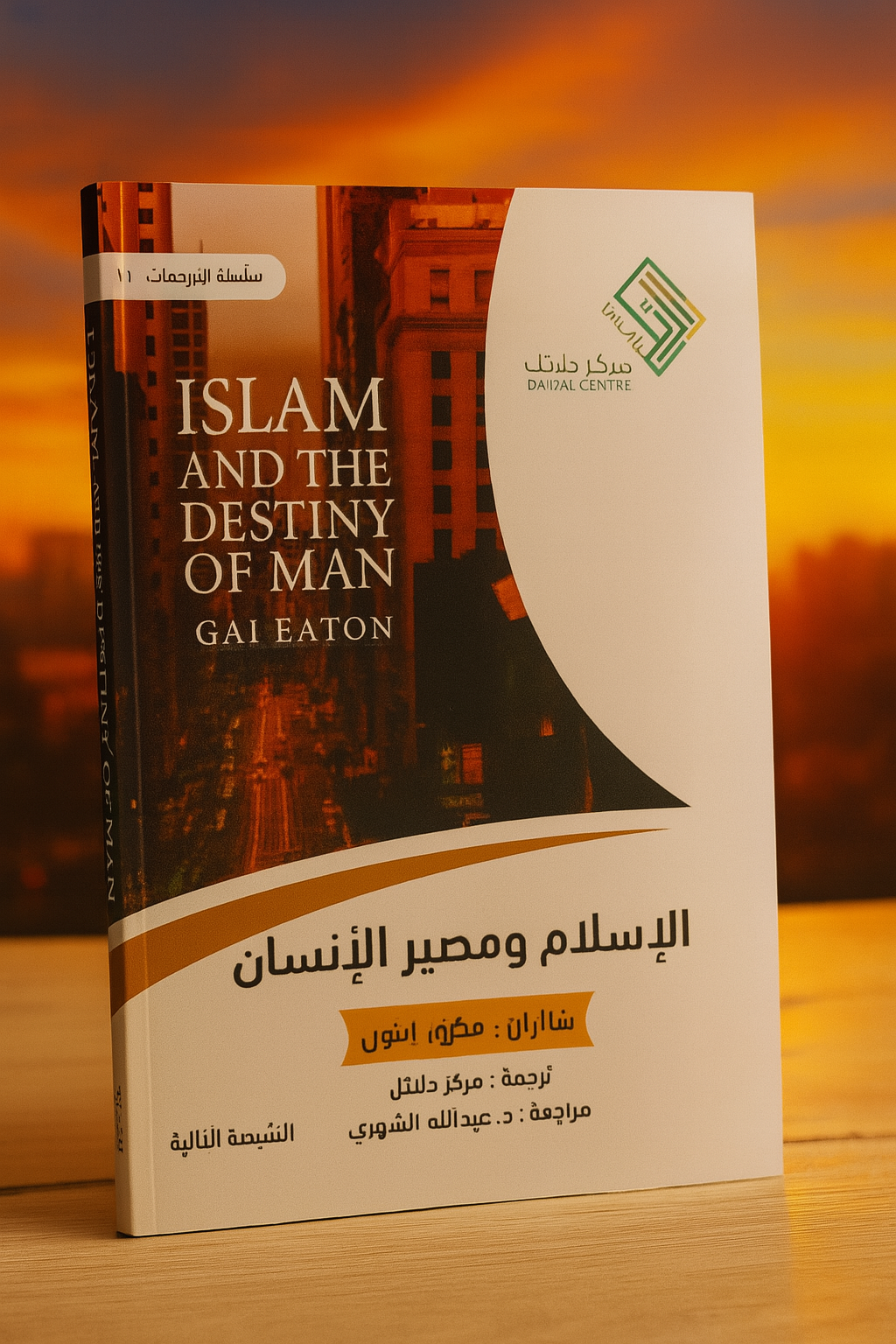 Photographie du livre Islam and the Destiny of Man de Gai Eaton, en version bilingue arabe-anglais, présenté debout sur une table en bois clair, avec en arrière-plan un ciel flamboyant aux teintes orangées. La couverture combine une vue urbaine en perspective au crépuscule et un design épuré, avec le logo du Dalāl Centre et les informations de traduction en arabe.