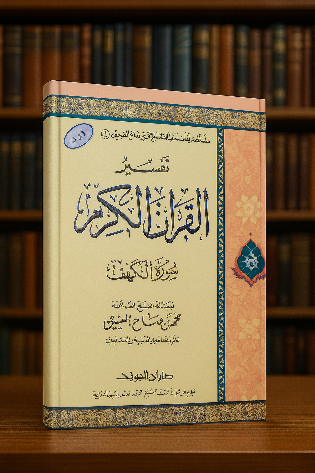 Photographie d’un livre en arabe intitulé Tafsir al-Qur'an al-Karim – Sourate al-Kahf du cheikh Muhammad ibn Salih al-‘Uthaymin, posé verticalement sur une surface claire. La couverture présente un fond crème et rose décoré de motifs islamiques et d'arabesques, avec une calligraphie soignée au centre